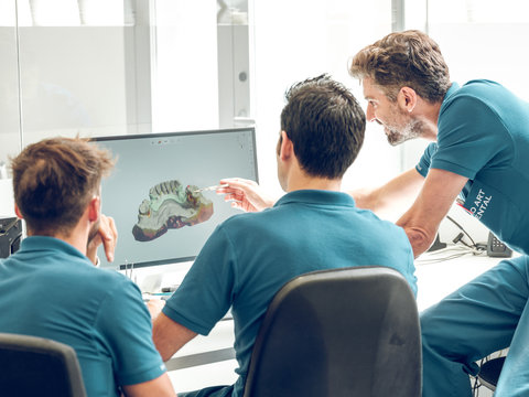 Dentists modeling jaw on computer