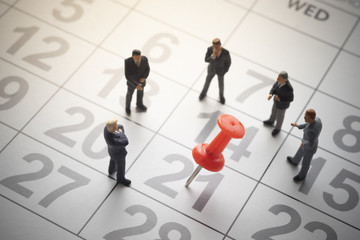 Businessmen with pinned calendar.