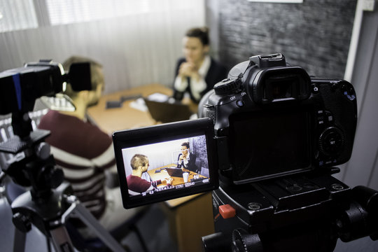 camera on the set of a business meeting between a man and a woman