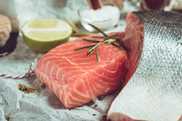 Fresh Salmon Fillet with Lime and Aromatic Herbs and Spices on White Paper