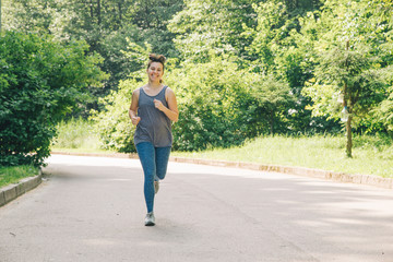 young adult woman running by city park with music. healthy lifes