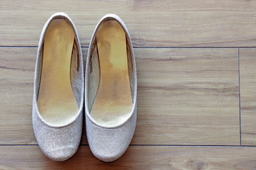 Gold Wedding pumps on wooden floor