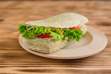 Tasty hamburger with meat and vegetables against a wooden background. Fast food. It can be used as a background