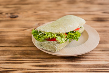 Tasty hamburger with meat and vegetables against a wooden background. Fast food. It can be used as a background