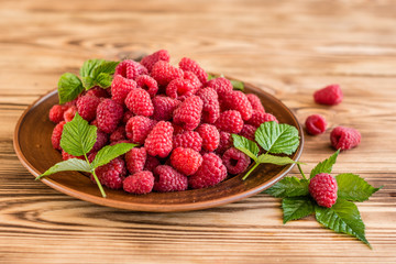 Tasty juicy sweet raspberry on a wooden background. It can be used as a background
