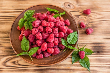 Tasty juicy sweet raspberry on a wooden background. It can be used as a background
