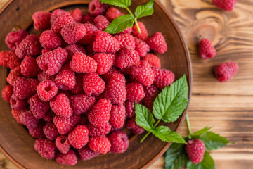 Tasty juicy sweet raspberry on a wooden background. It can be used as a background