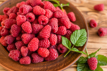 Tasty juicy sweet raspberry on a wooden background. It can be used as a background