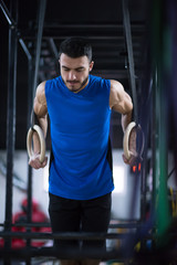 man working out pull ups with gymnastic rings