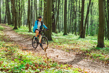 couple riding bicycle in forest in warm day
