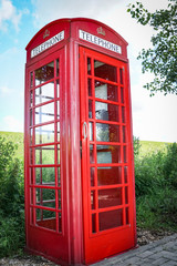 Hübsche, altmodische, rote Telefonzelle im britischen Stil