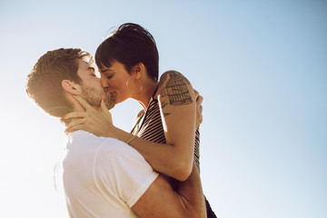 Beautiful couple kissing outdoors - obrazy, fototapety, plakaty