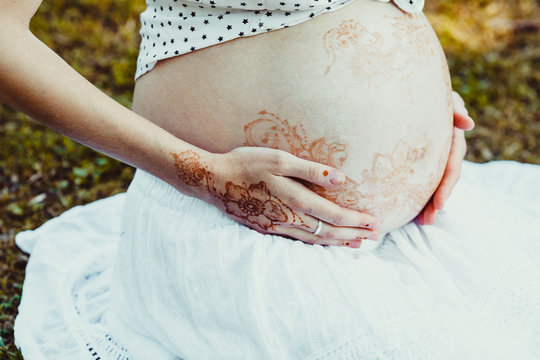 Close up the pregnant belly with mehndi