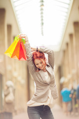 Beautiful young woman shopping in the city, mall with shopping bag, with colorful carrying bags