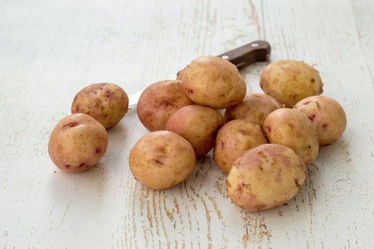 Young fresh early potatoes on a wooden old table.