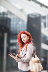 young beautiful business woman holding tablet, working in downtown, outdoors 
