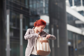 young beautiful business woman holding purse, working in downtown, outdoors - 209910499