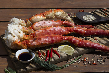 Fresh crab claws with sauce, pepper and lemon on vintage wooden background.    © mafffi