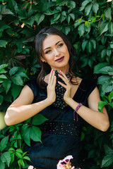 Portrait of young sexy brunette with black grapes.