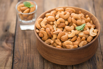 cashew nuts in wood bowl on old wood table

