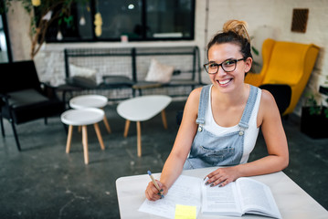 Portrait of a girl in eyeglasses studying. Looking at camera.