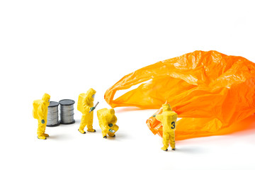 The figurines in protective suit examine an orange used plastic bag isolated on white background