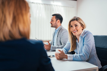 Happy business people discussing in meeting.