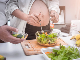 Pregnancy healthy food and people concept.future dad and mom eating healthy salad and take care together.