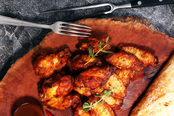 barbecue chicken wings close up on wooden tray