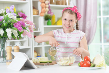 Cute girl preparing delicious fresh salad