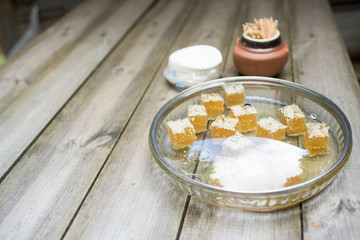 Sweet honey in cubes on the wooden background