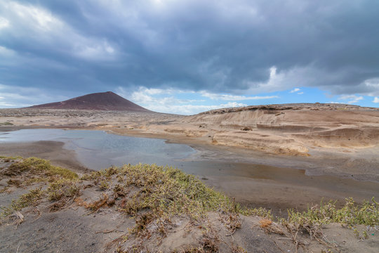 Landscape of a mountain and a lake, with some storm clouds. Views of the M&eacute;dano in Tenerife, Canary Islands.