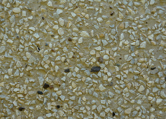 Pebbles gravel on the wall gray texture with black impregnations.