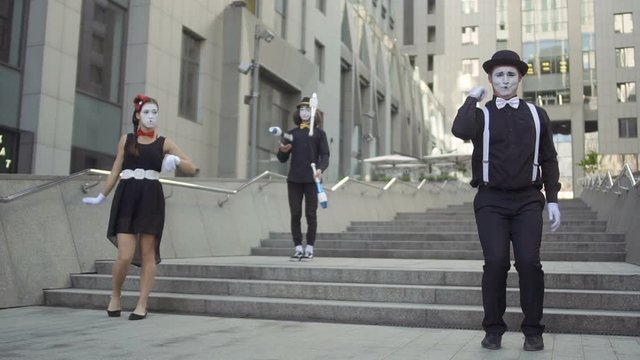 Three mimes have fun standing near office center