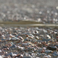 Pebbles gravel on the ground gray texture in perspective