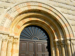 Obraz premium Medieval entrance in the form of an arch with a carved stone portico with columns.