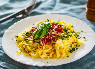 Linguine pasta with fresh tomato sauce, grated cheese and basil in white plate