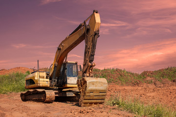 Fototapeta na wymiar Orange excavator is on a backround of sunset.