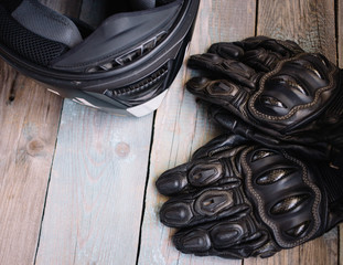 motorcycle helmet and gloves on dark wooden background
