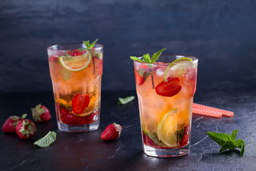 Strawberry mojito cocktail with berries, lime and mint. Summer berry cocktail on black background. horizontal