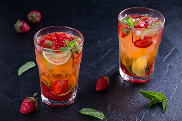 Strawberry mojito cocktail with berries, lime and mint. Summer berry cocktail on black background. horizontal