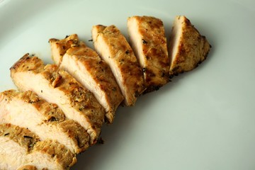 grilled chicken breast on a plate from above. grillfleisch sliced, carved.