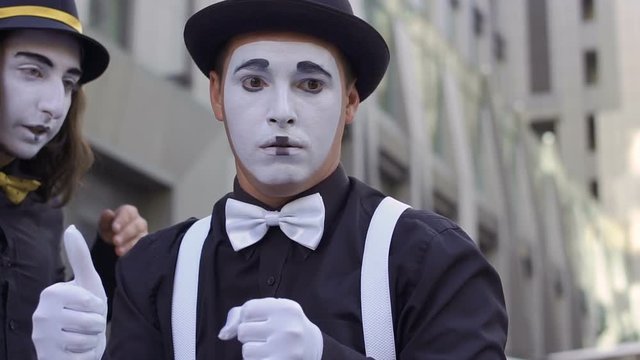 Two men mimes have fun in front of camera