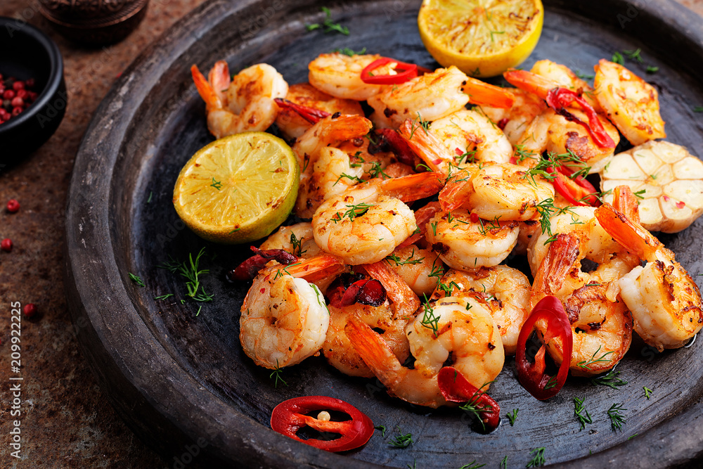 Wall mural prawns shrimps roasted on pan with lemon and garlic on dark rustic background. top view.