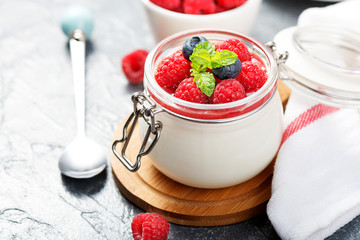 Delicious italian dessert panna cotta with raspberry sauce, fresh berries and mint on gray background. - obrazy, fototapety, plakaty