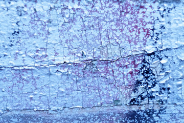 Fragment of an old wooden surface covered with layers of cracked paint