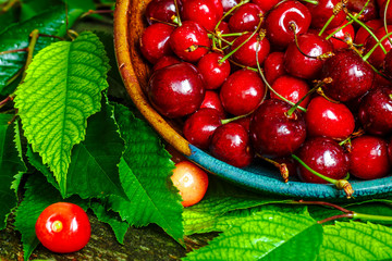 Cherries on wooden table with water drops macro background