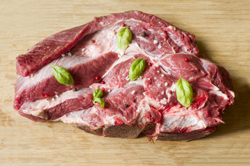 A piece of red raw beef meat on wooden cutting Board Dark background