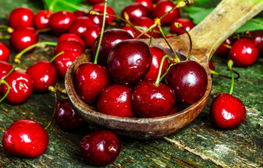 Cherries on wooden table with water drops macro background