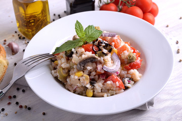 Rice salad with vegetables on white plate 
 